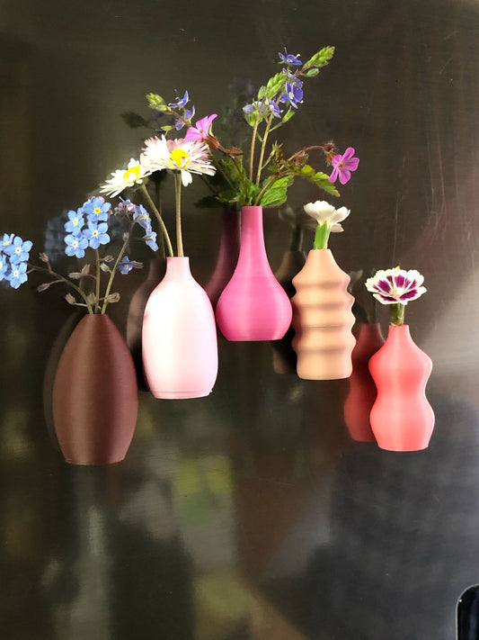 Child handing a tiny flower to their mom, with a magnetic mini vase on the fridge in the background—capturing a heartwarming everyday moment