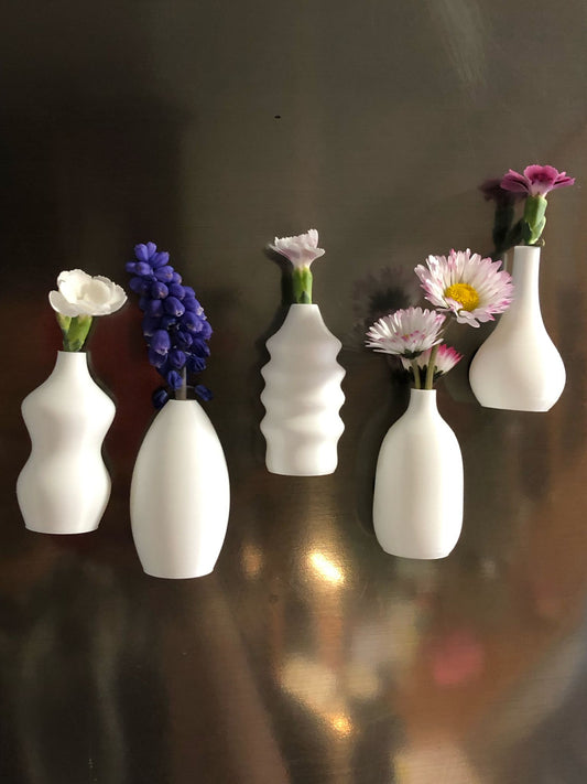Child handing a tiny flower to their mom, with a magnetic mini vase on the fridge in the background—capturing a heartwarming everyday moment
