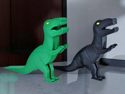 Green and black dinosaur-shaped door stoppers on a surface.