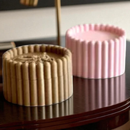 3D printed macaron-style jar with a rounded lid and ribbed cookie-like sides, shown in brown and pink colors, used for vanity or bathroom storage.