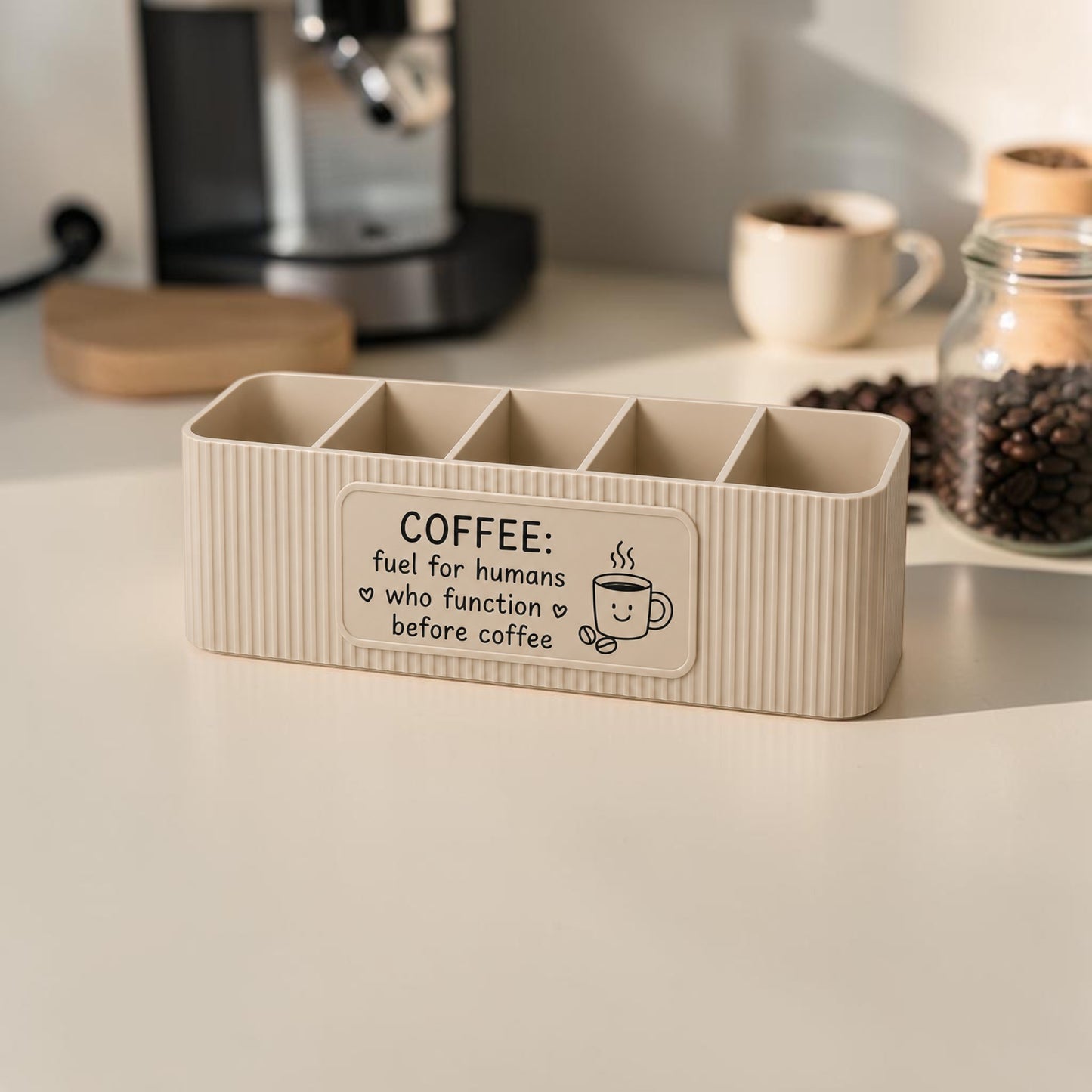 personalised five compartment coffee station organiser with ribbed finish and custom uv printed front message, designed for storing coffee sachets, tea bags, sugar packets, creamer, spoons and stirrers on a kitchen countertop. available in white, caramel, grey, pink, dark blue water and lavender purple.