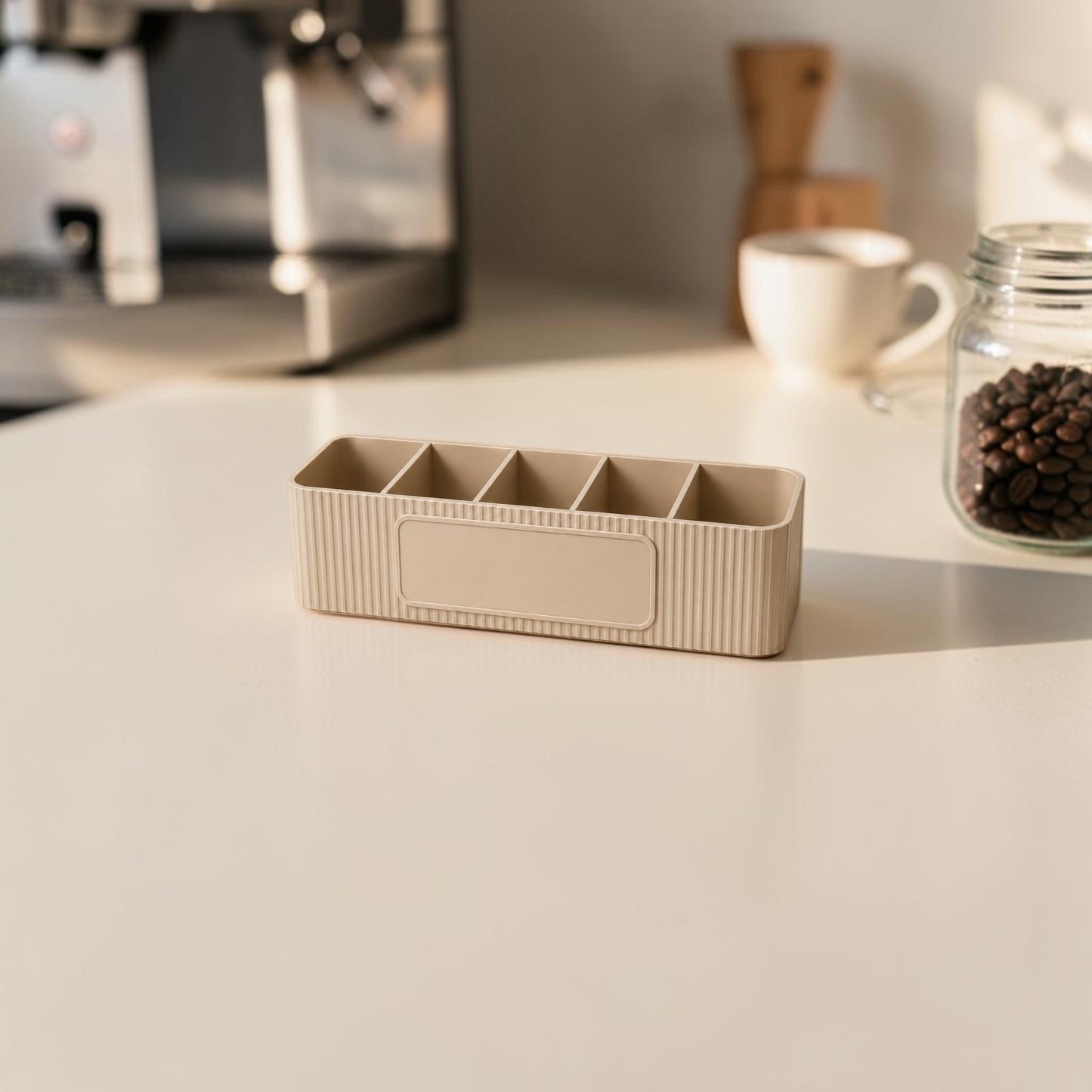 personalised five compartment coffee station organiser with ribbed finish and custom uv printed front message, designed for storing coffee sachets, tea bags, sugar packets, creamer, spoons and stirrers on a kitchen countertop. available in white, caramel, grey, pink, dark blue water and lavender purple.