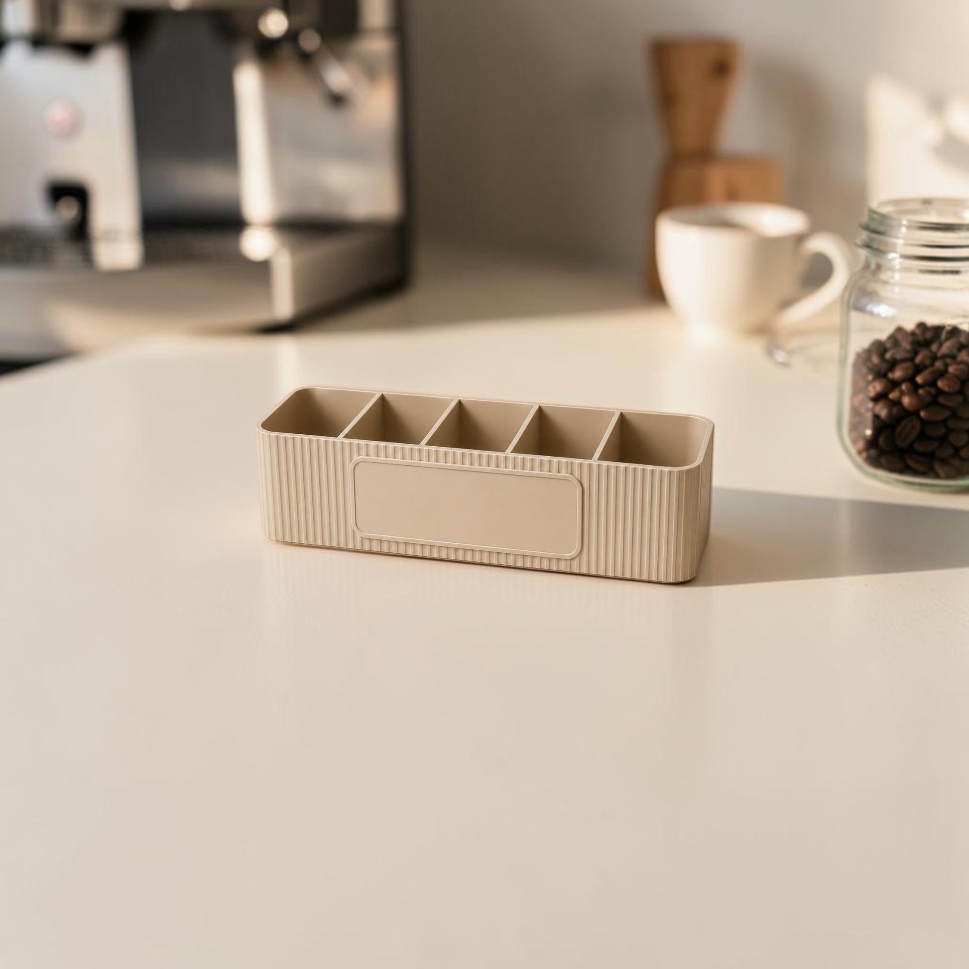 Personalised five compartment coffee station organiser with ribbed finish and custom UV printed front message, designed for storing coffee sachets, tea bags, sugar packets, creamer, spoons and stirrers on a kitchen countertop. Available in white, caramel, grey, pink, dark Blue Water and Lavender Purple.