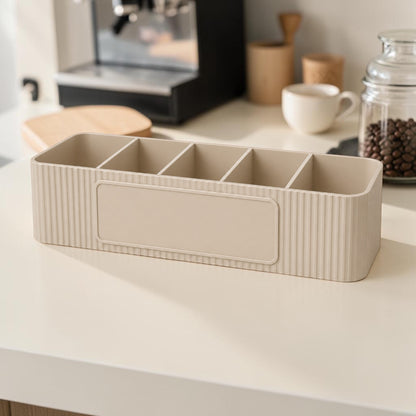 Personalised five compartment coffee station organiser with ribbed finish and custom UV printed front message, designed for storing coffee sachets, tea bags, sugar packets, creamer, spoons and stirrers on a kitchen countertop. Available in white, caramel, grey, pink, dark Blue Water and Lavender Purple.