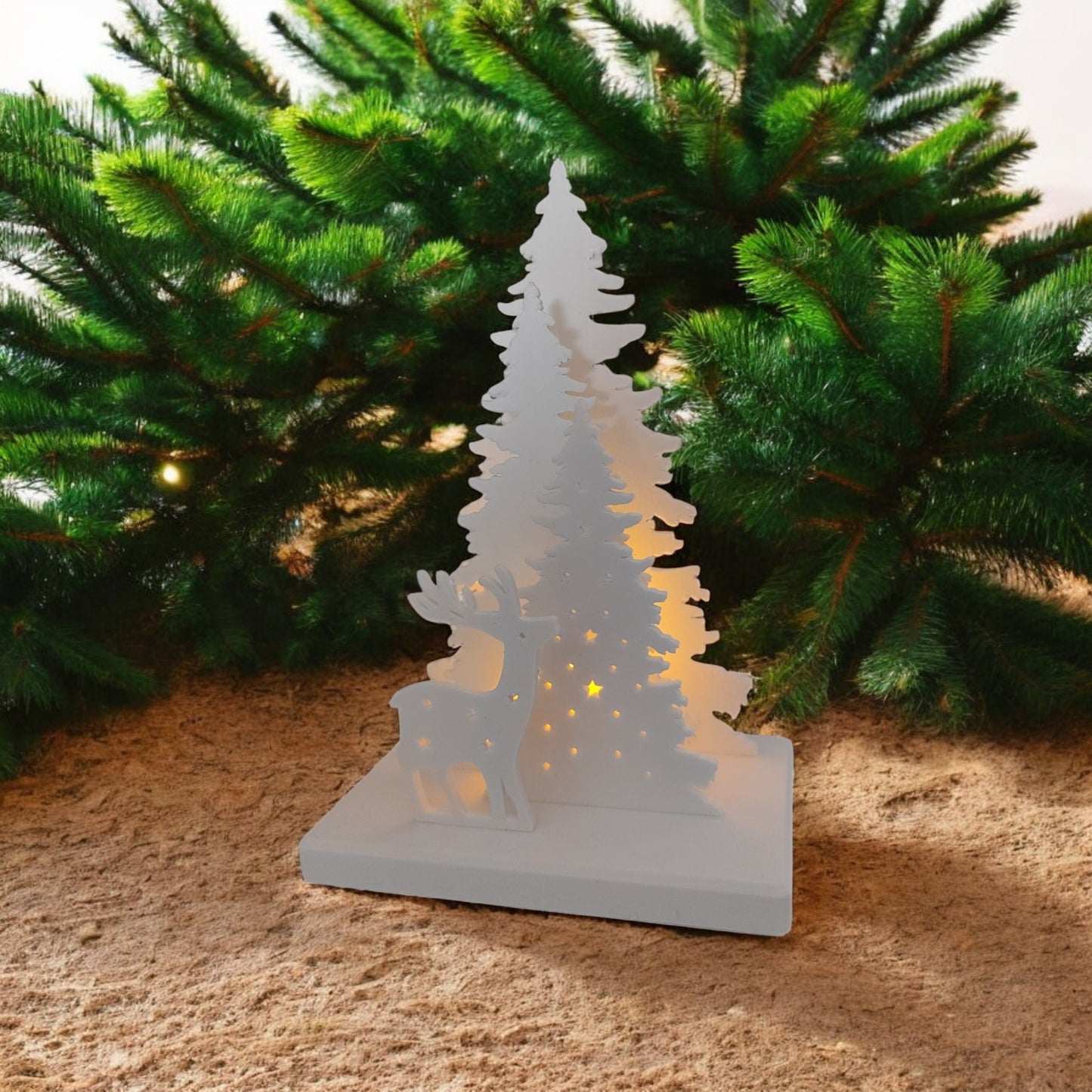 white christmas reindeer and pine tree led tealight decoration glowing on table, festive holiday décor for mantel or centerpiece.