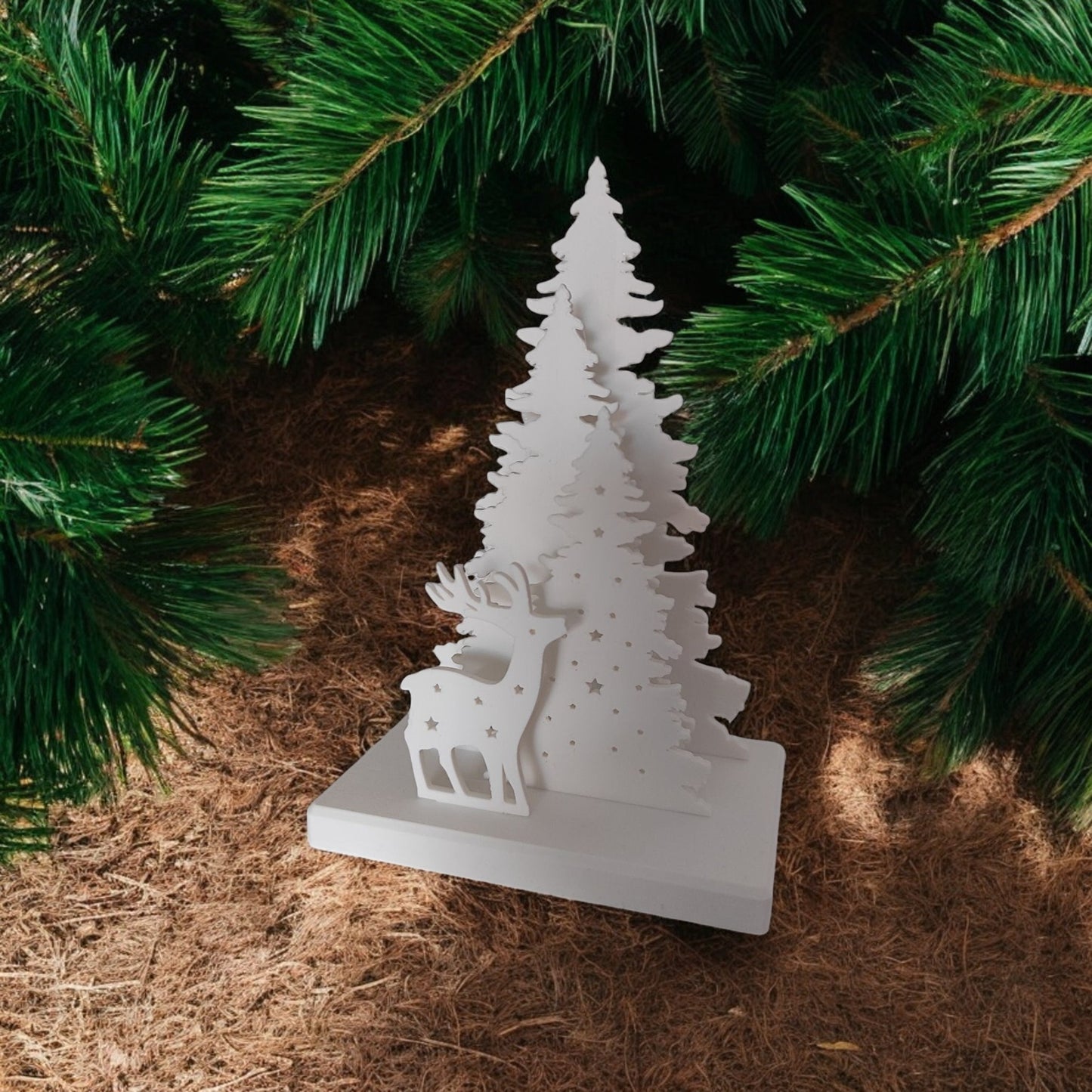 white christmas reindeer and pine tree led tealight decoration glowing on table, festive holiday décor for mantel or centerpiece.