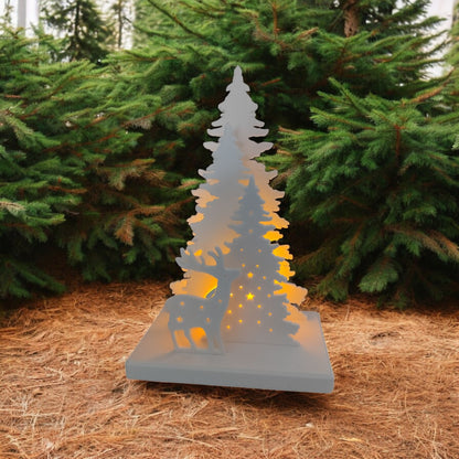 White Christmas reindeer and pine tree LED tealight decoration glowing on table, festive holiday décor for mantel or centerpiece.