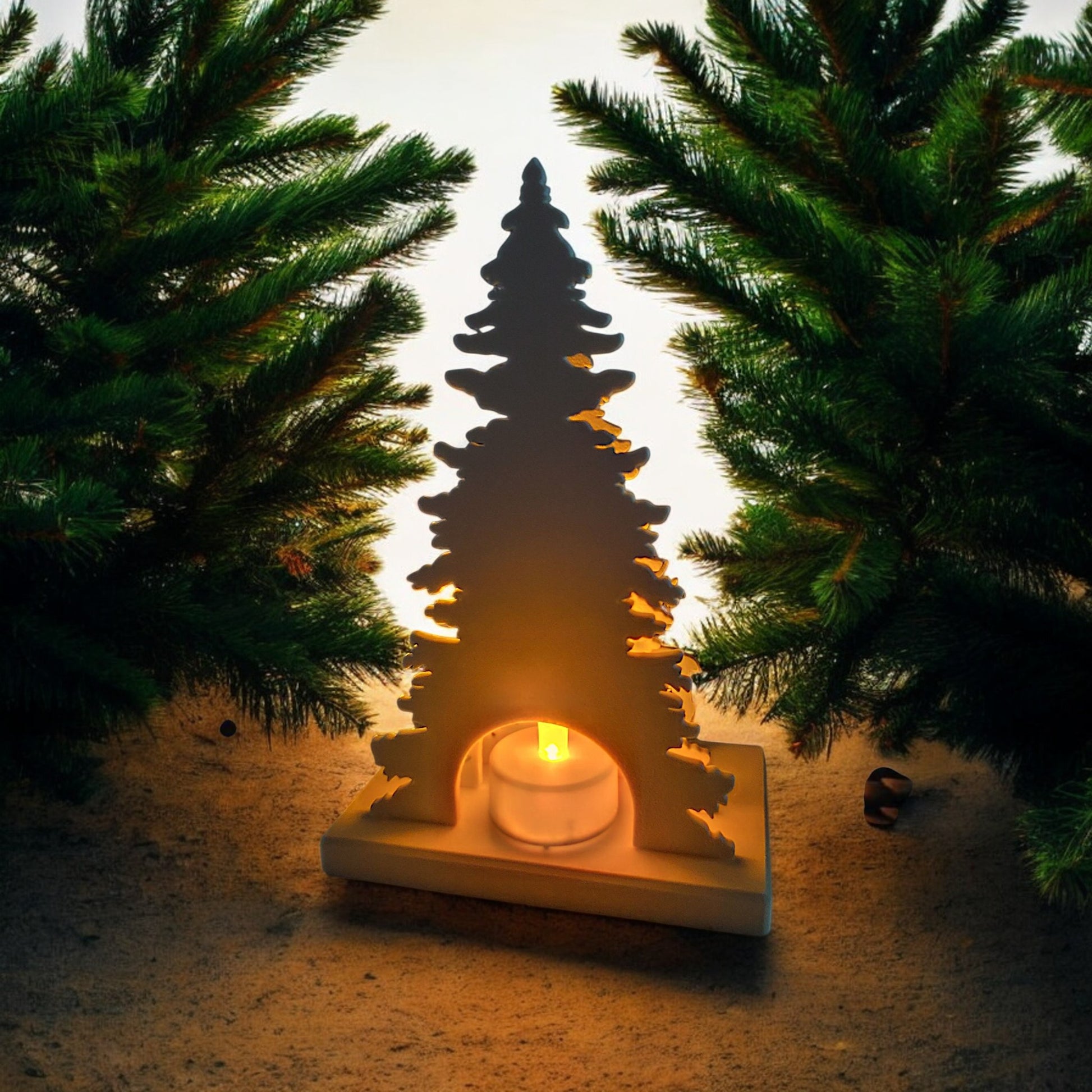 White Christmas reindeer and pine tree LED tealight decoration glowing on table, festive holiday décor for mantel or centerpiece.