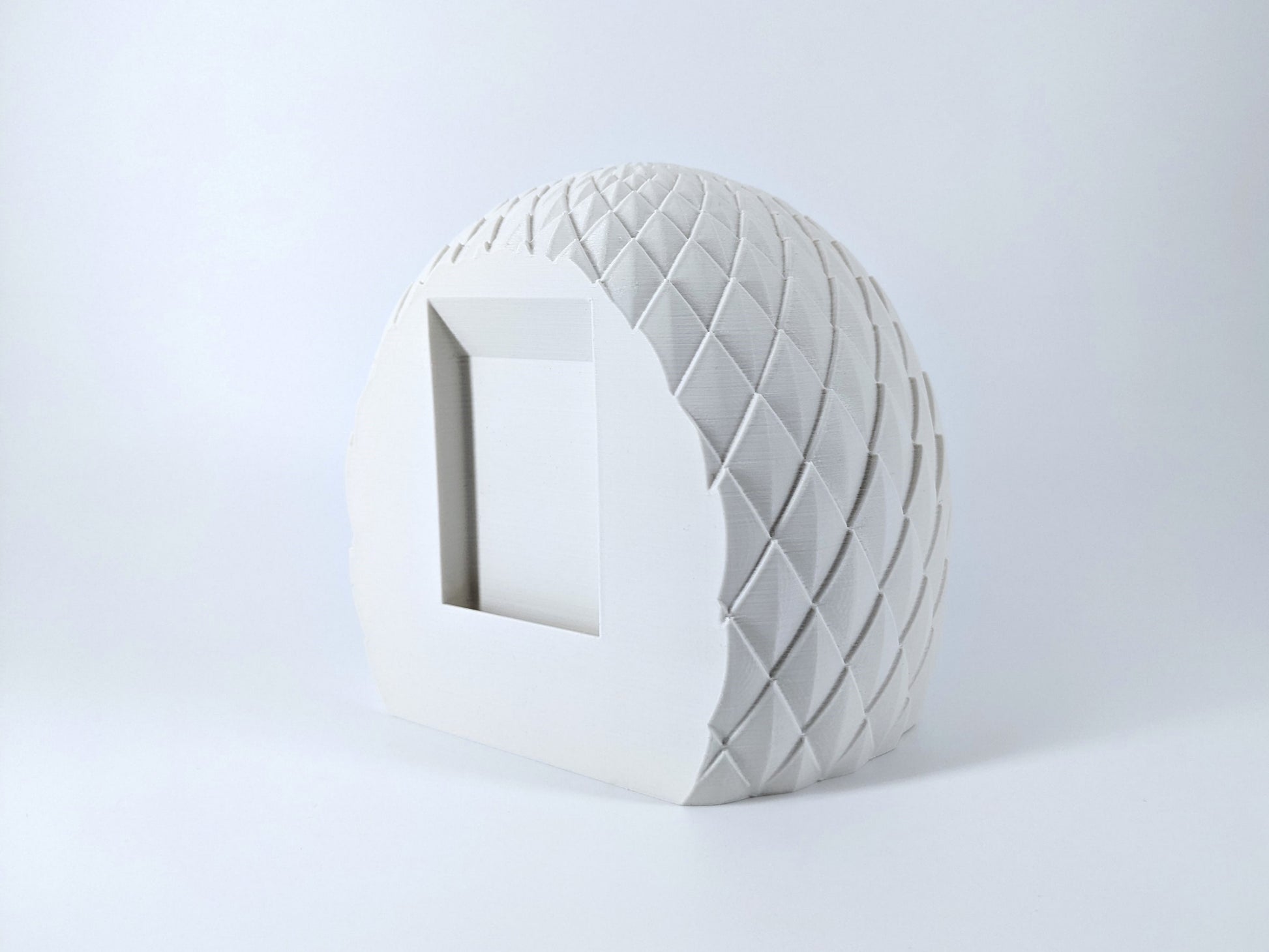 White ceramic vase with textured surface on a light gray background