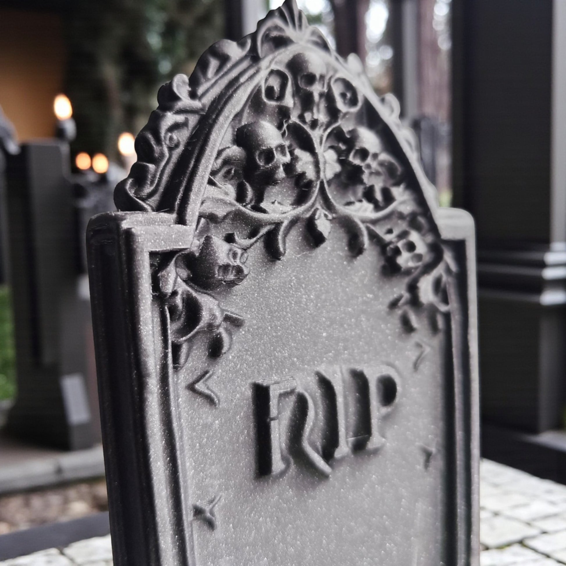 3D printed gothic gravestone with skull details and “RIP” engraving, available in black, grey, and white, shown as Halloween or gothic table decor.