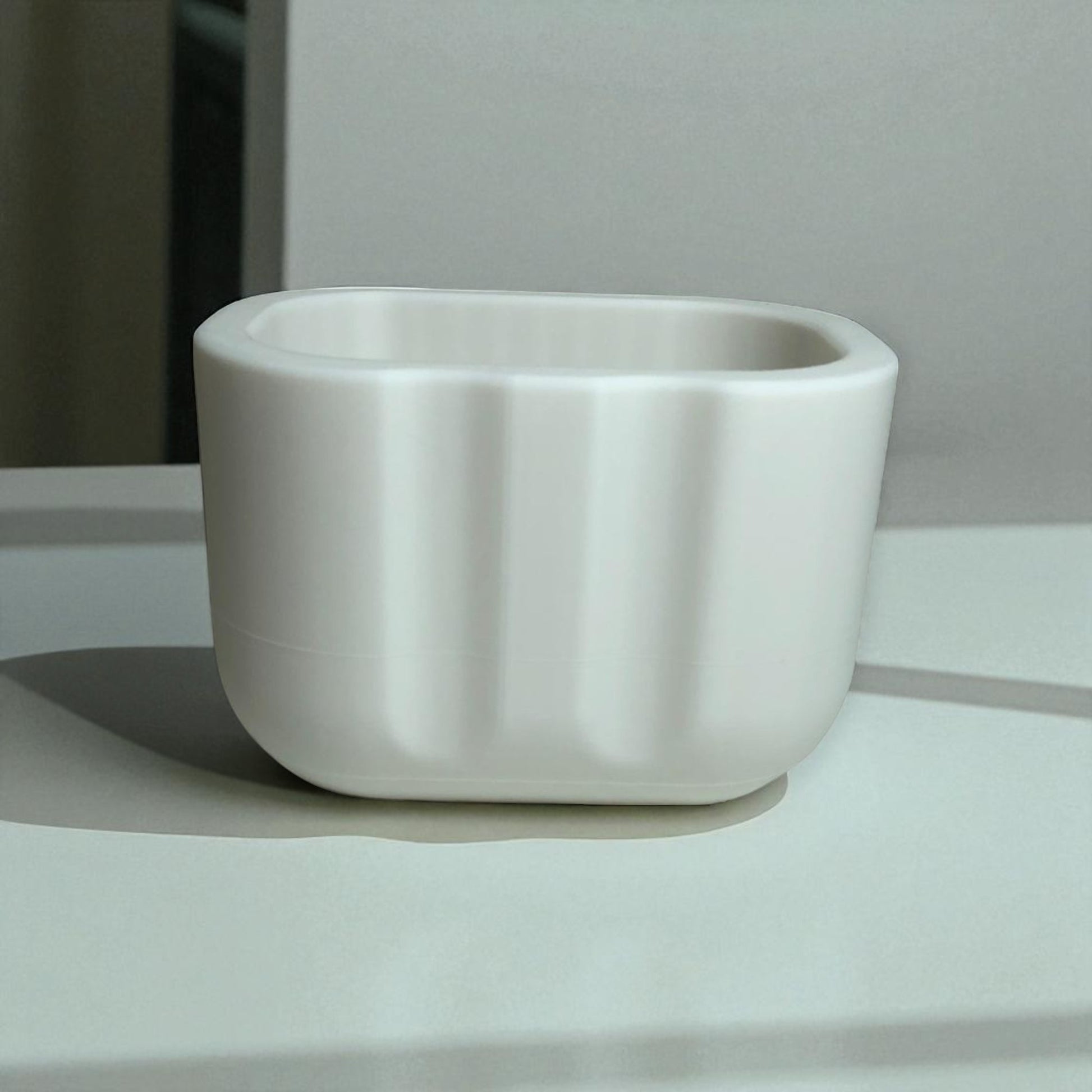 Black sponge holder with a yellow sponge on a kitchen counter