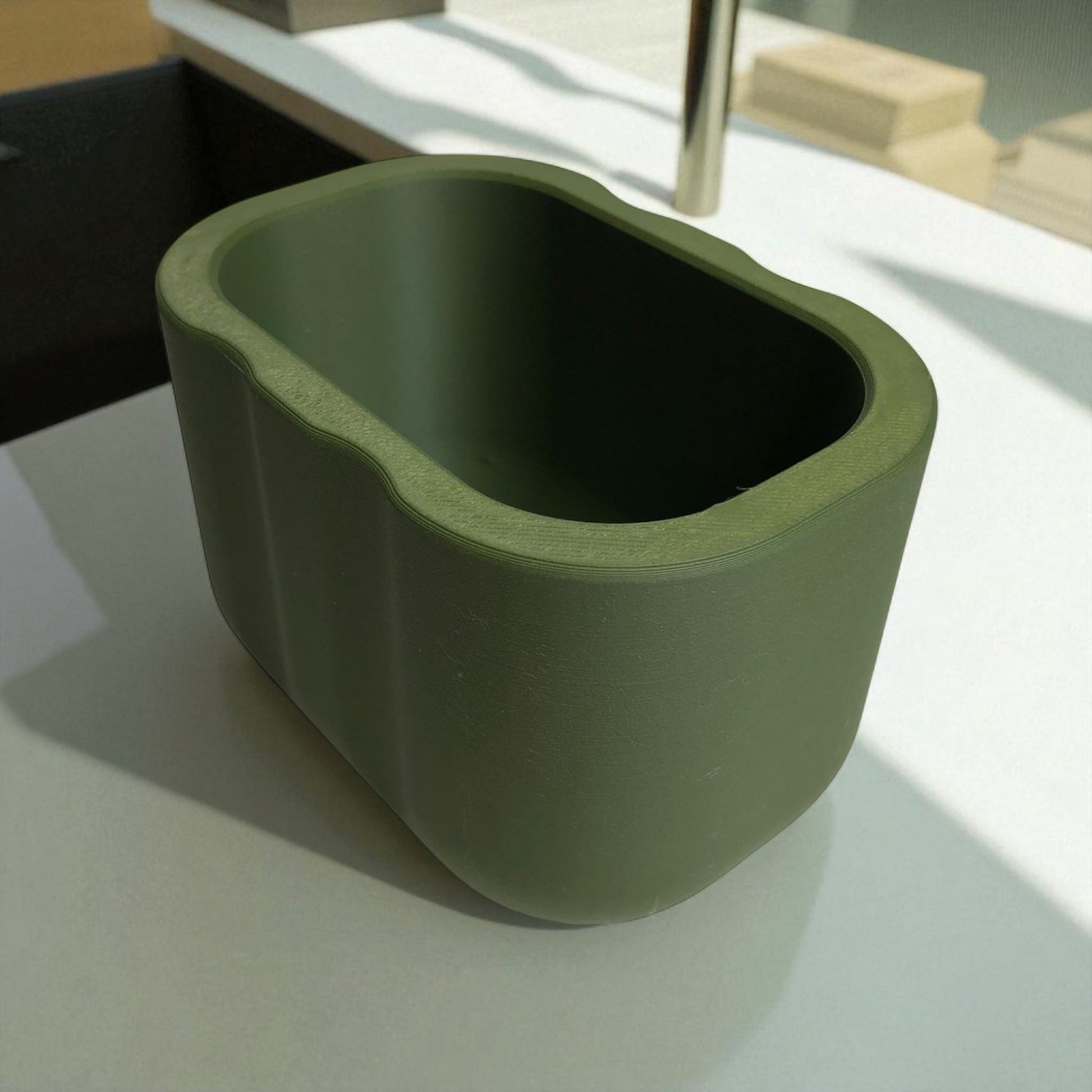 Black sponge holder with a yellow sponge on a kitchen counter