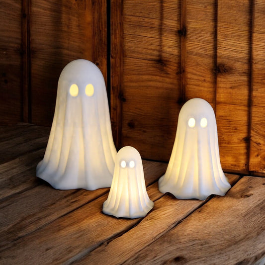 Set of 3 glowing ghost LED tealight holders in small, medium, and large sizes, for indoor or outdoor Halloween decor.