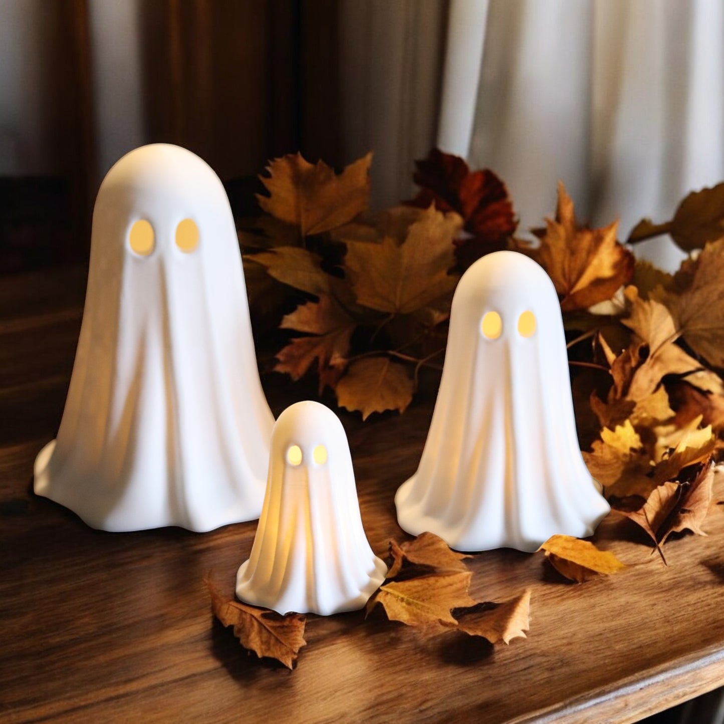 set of 3 glowing ghost led tealight holders in small, medium, and large sizes, for indoor or outdoor halloween decor.