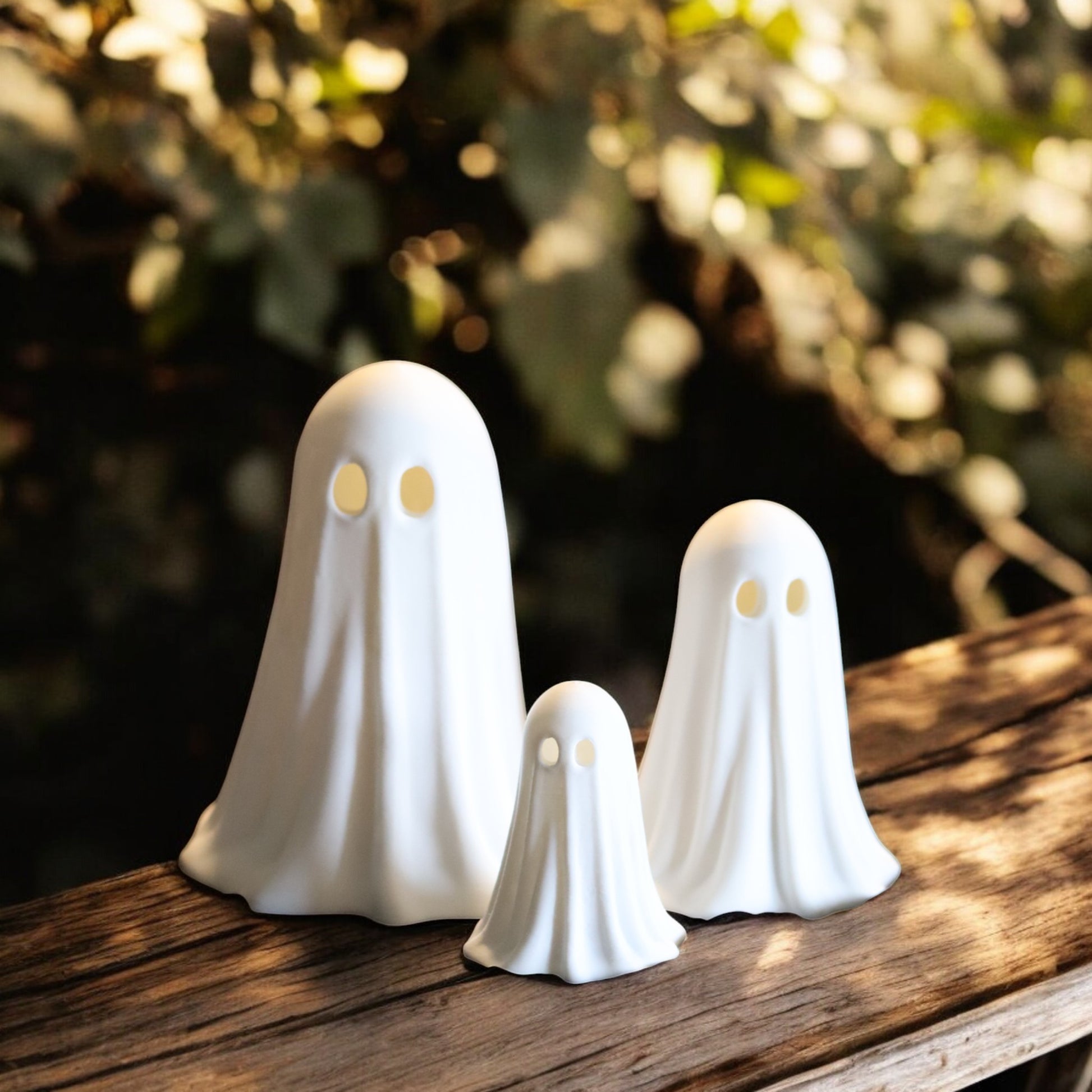 Set of 3 glowing ghost LED tealight holders in small, medium, and large sizes, for indoor or outdoor Halloween decor.
