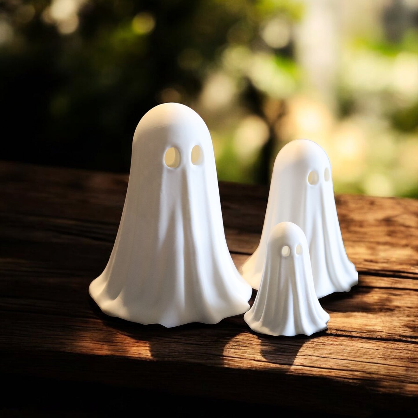 set of 3 glowing ghost led tealight holders in small, medium, and large sizes, for indoor or outdoor halloween decor.