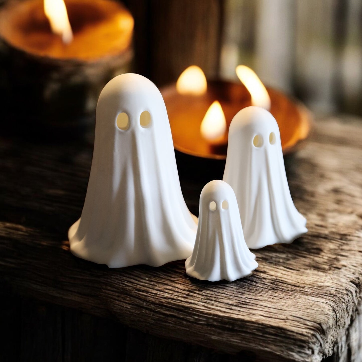set of 3 glowing ghost led tealight holders in small, medium, and large sizes, for indoor or outdoor halloween decor.