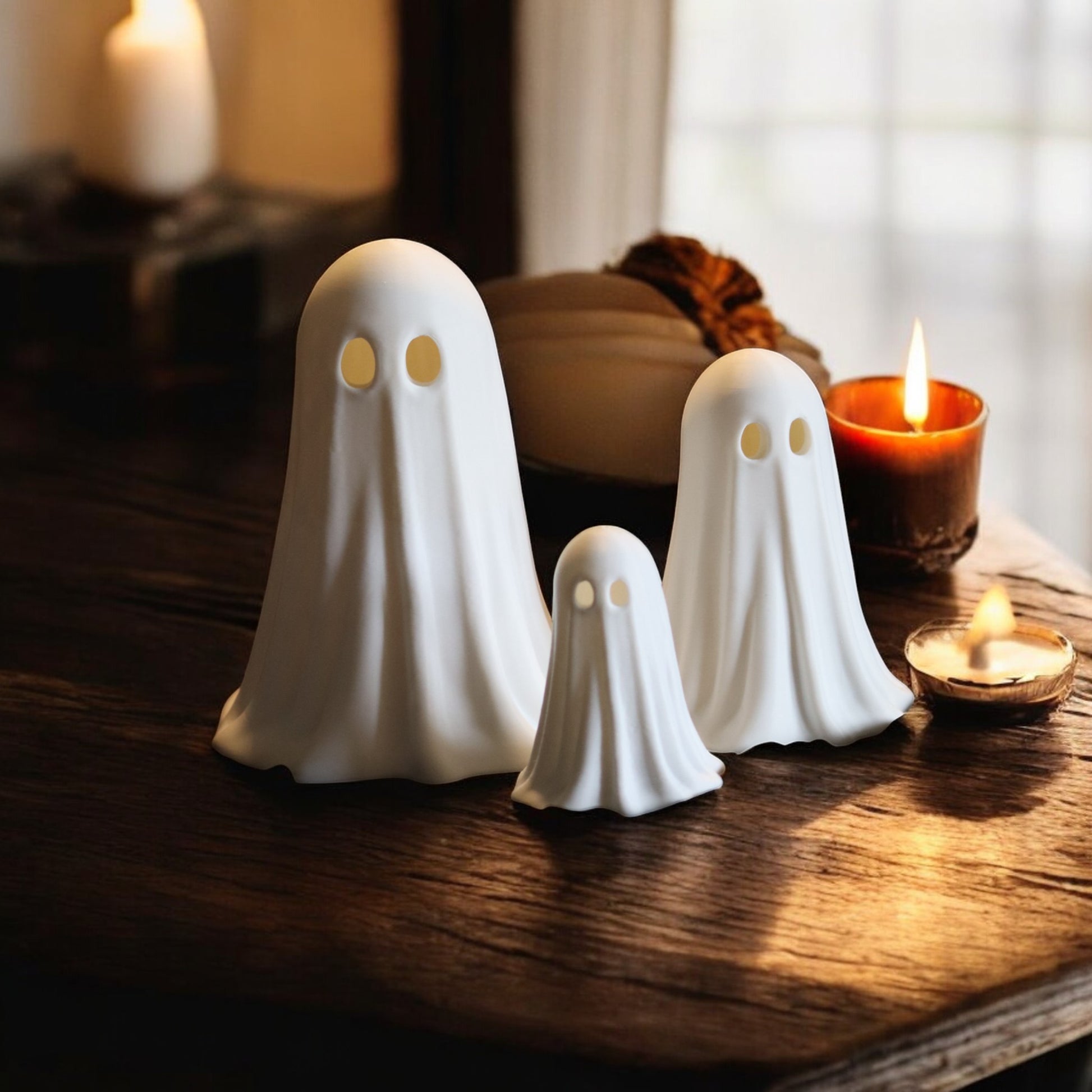 Set of 3 glowing ghost LED tealight holders in small, medium, and large sizes, for indoor or outdoor Halloween decor.
