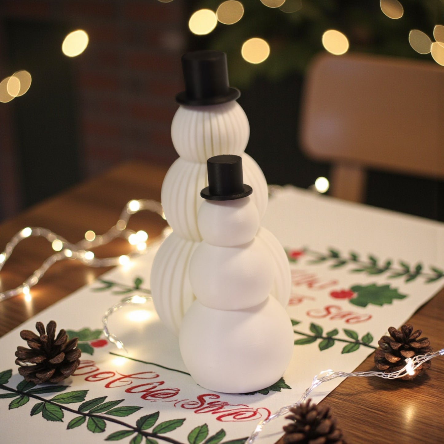 two white snowman figurines, one ribbed and one smooth, each with a small black top hat. minimalist christmas decor displayed on a countertop in small and large sizes.