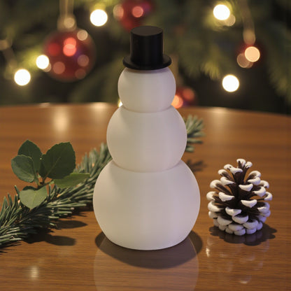 Two white snowman figurines, one ribbed and one smooth, each with a small black top hat. Minimalist Christmas decor displayed on a countertop in small and large sizes.