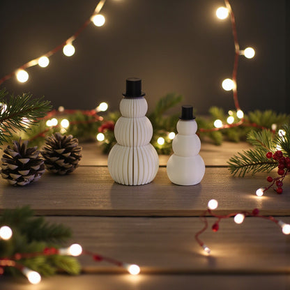 Two white snowman figurines, one ribbed and one smooth, each with a small black top hat. Minimalist Christmas decor displayed on a countertop in small and large sizes.