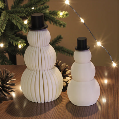 Two white snowman figurines, one ribbed and one smooth, each with a small black top hat. Minimalist Christmas decor displayed on a countertop in small and large sizes.