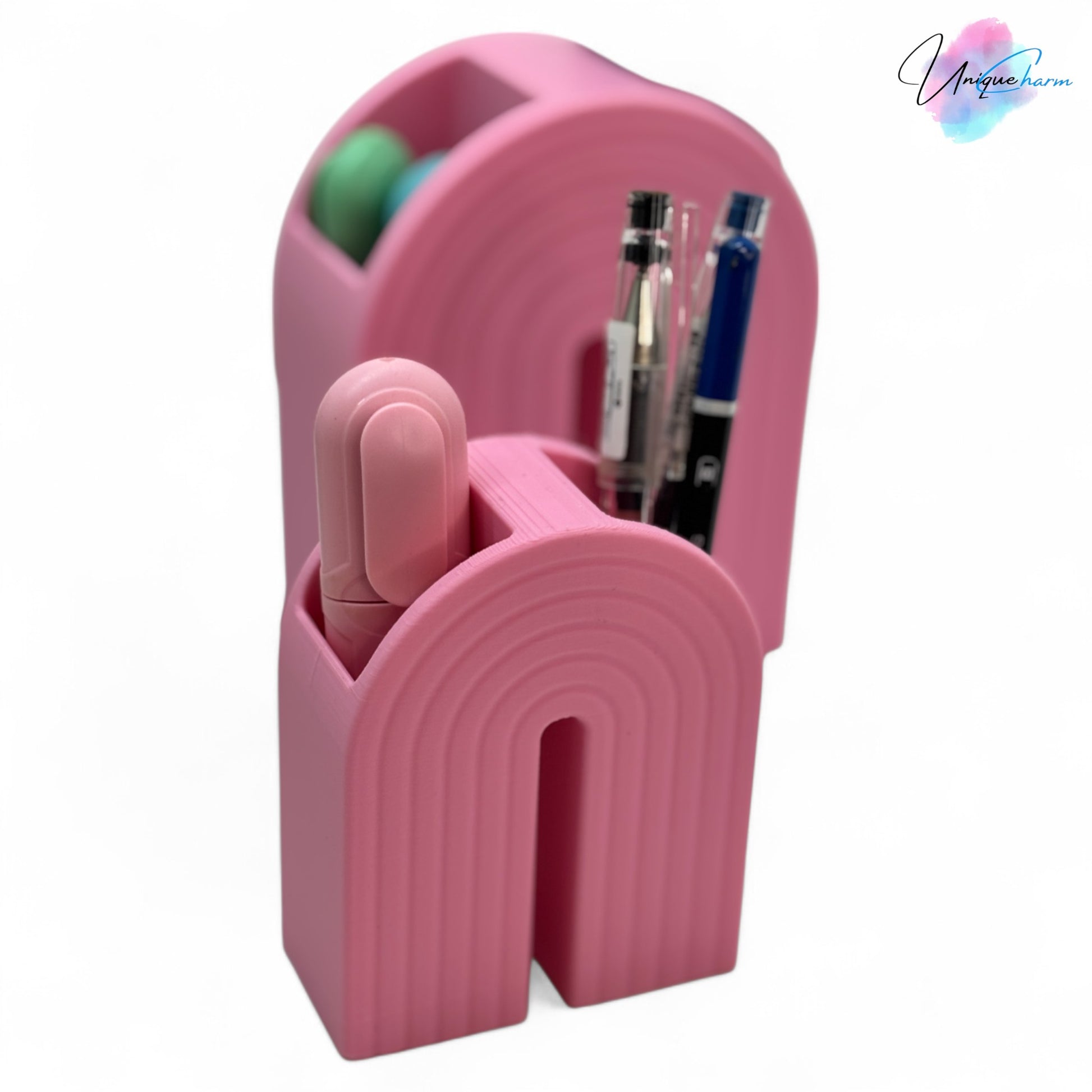 Colorful 3D printed rainbow-shaped organizer used as a bookend, pen holder, and mini vase, displayed in two sizes on a shelf with books, stationery, and dried flowers.