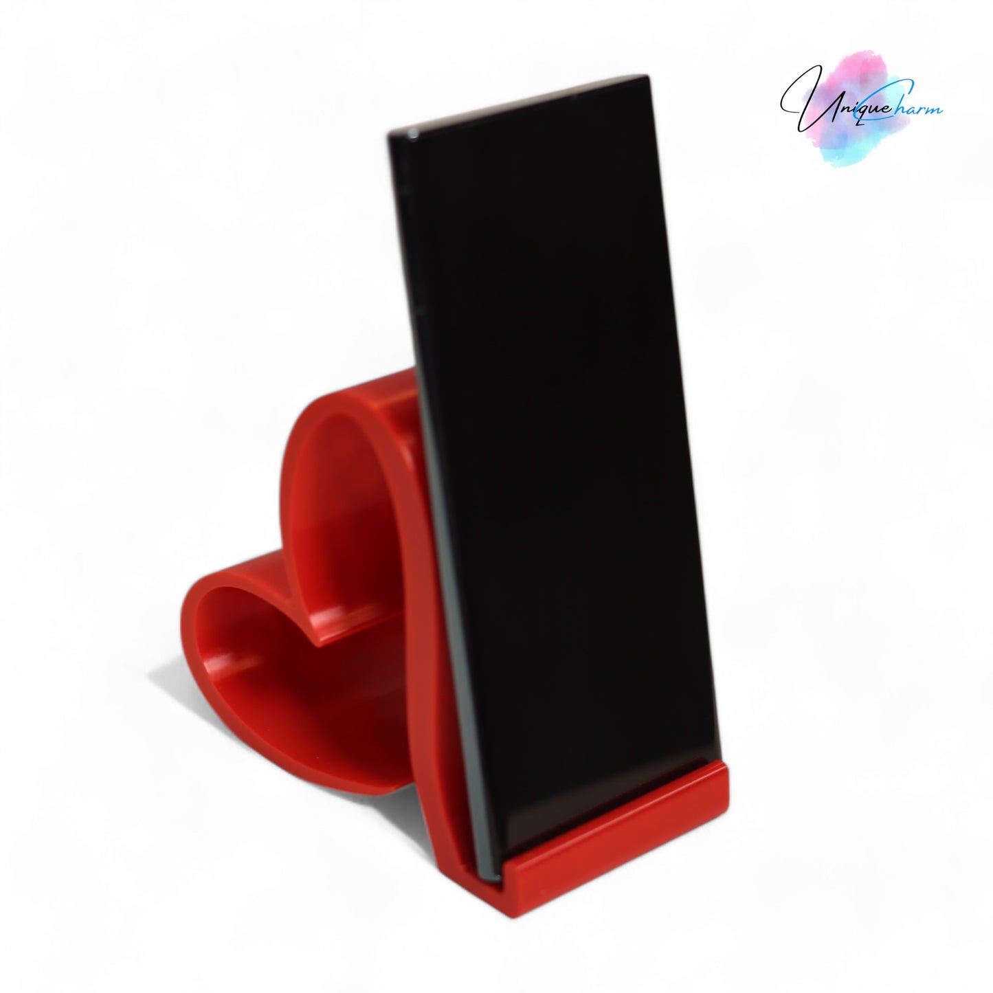 heart-shaped universal phone and kindle holder in an elegant design, securely holding a smartphone on a desk. stylish and versatile stand suitable for all phones, kindles, and small tablets, perfect for hands-free viewing