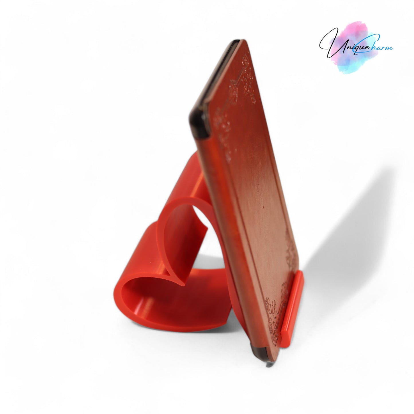 heart-shaped universal phone and kindle holder in an elegant design, securely holding a smartphone on a desk. stylish and versatile stand suitable for all phones, kindles, and small tablets, perfect for hands-free viewing