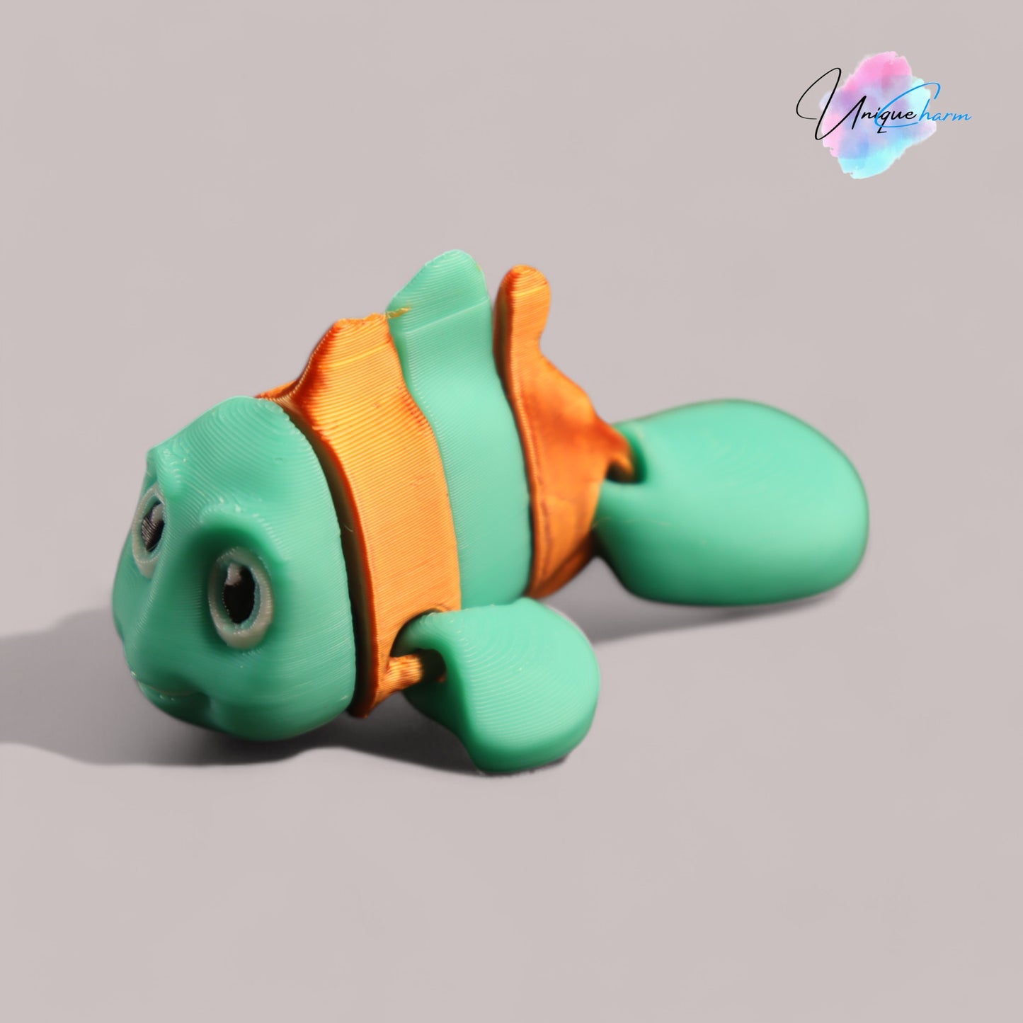 3d printed articulated clown fish toy in vibrant two-tone colors, featuring a cute face and flexible, lifelike movement, perfect as a keychain or playful ocean-themed gift.