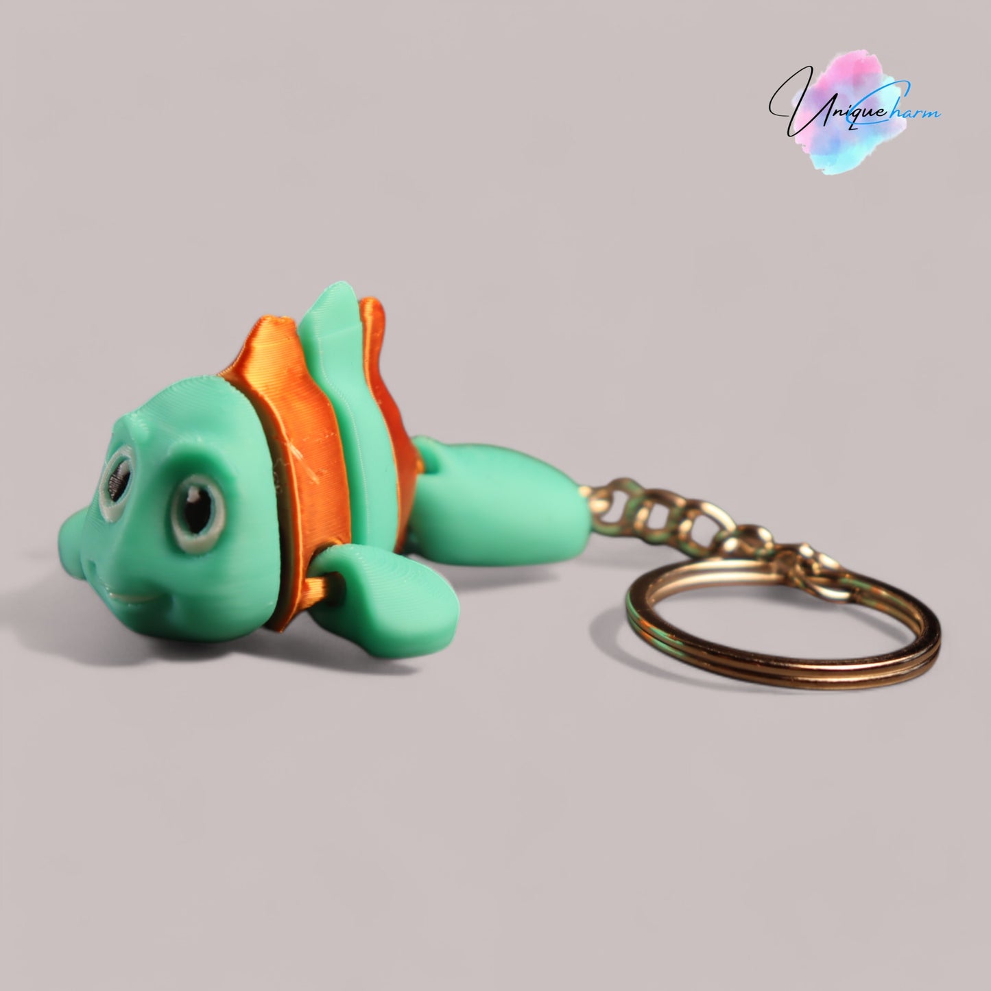 3d printed articulated clown fish toy in vibrant two-tone colors, featuring a cute face and flexible, lifelike movement, perfect as a keychain or playful ocean-themed gift.