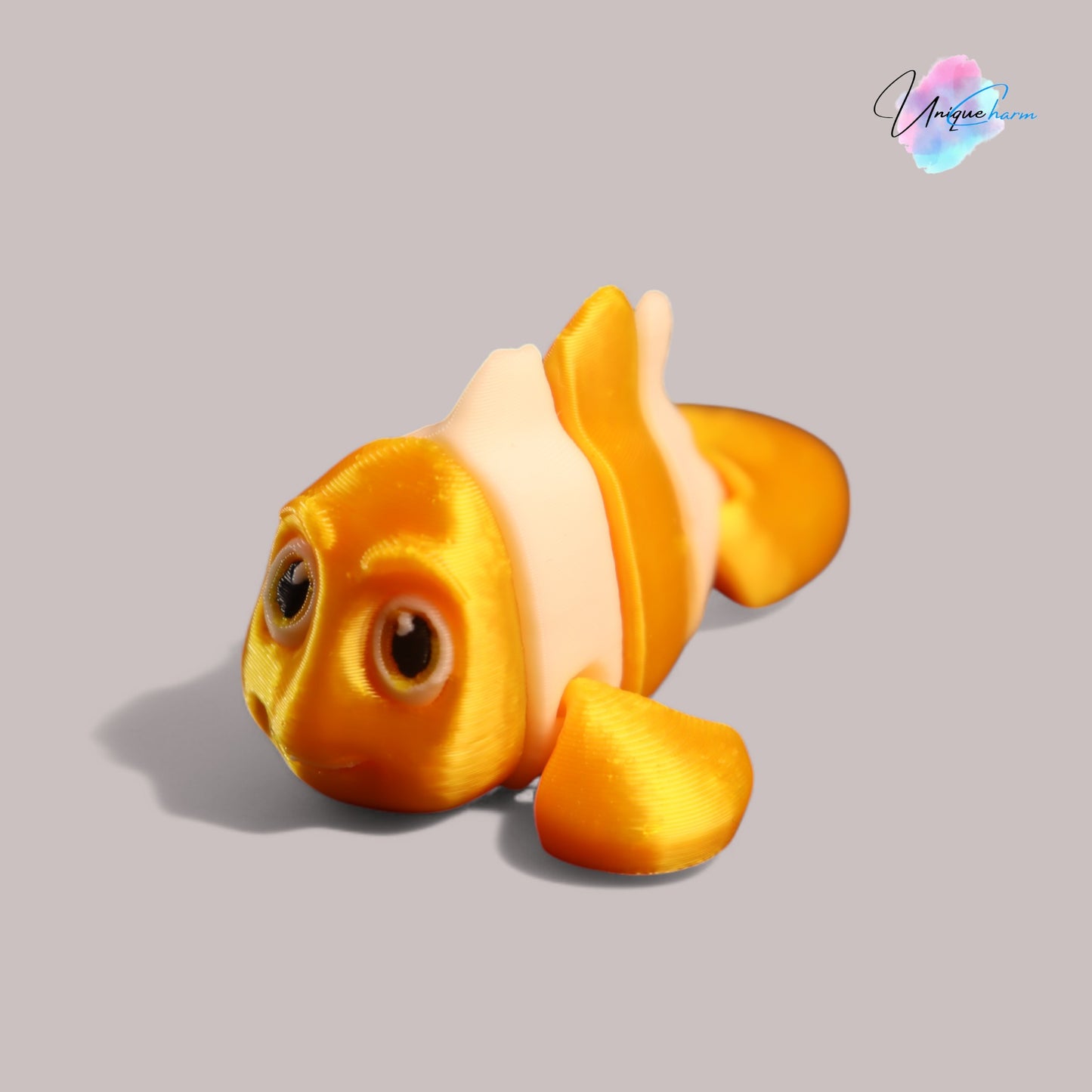 3d printed articulated clown fish toy in vibrant two-tone colors, featuring a cute face and flexible, lifelike movement, perfect as a keychain or playful ocean-themed gift.