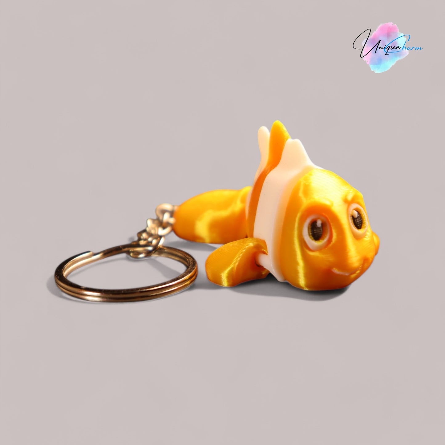 3d printed articulated clown fish toy in vibrant two-tone colors, featuring a cute face and flexible, lifelike movement, perfect as a keychain or playful ocean-themed gift.