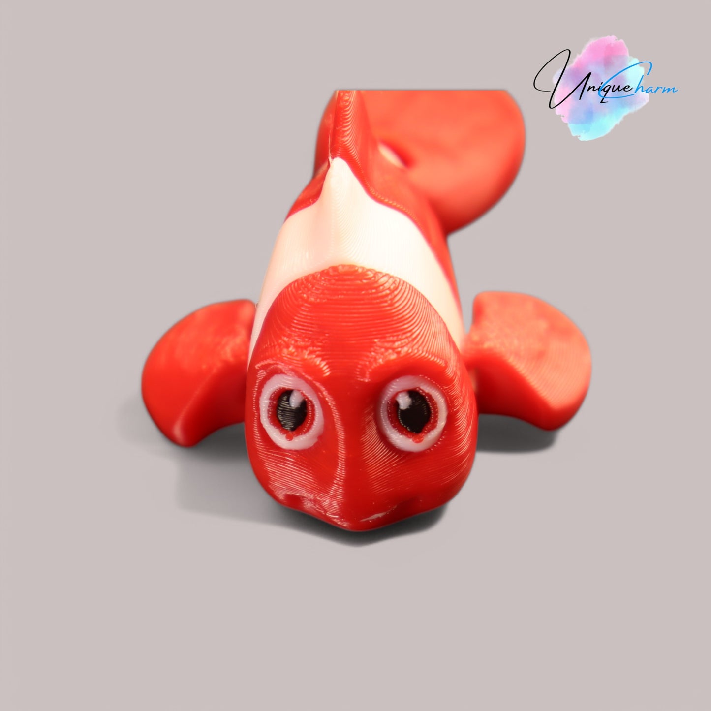 3d printed articulated clown fish toy in vibrant two-tone colors, featuring a cute face and flexible, lifelike movement, perfect as a keychain or playful ocean-themed gift.