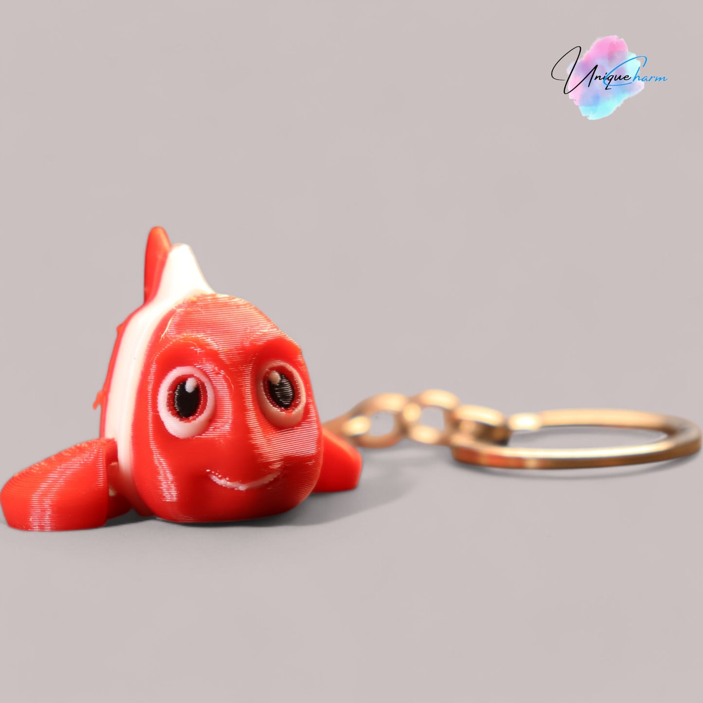 3d printed articulated clown fish toy in vibrant two-tone colors, featuring a cute face and flexible, lifelike movement, perfect as a keychain or playful ocean-themed gift.