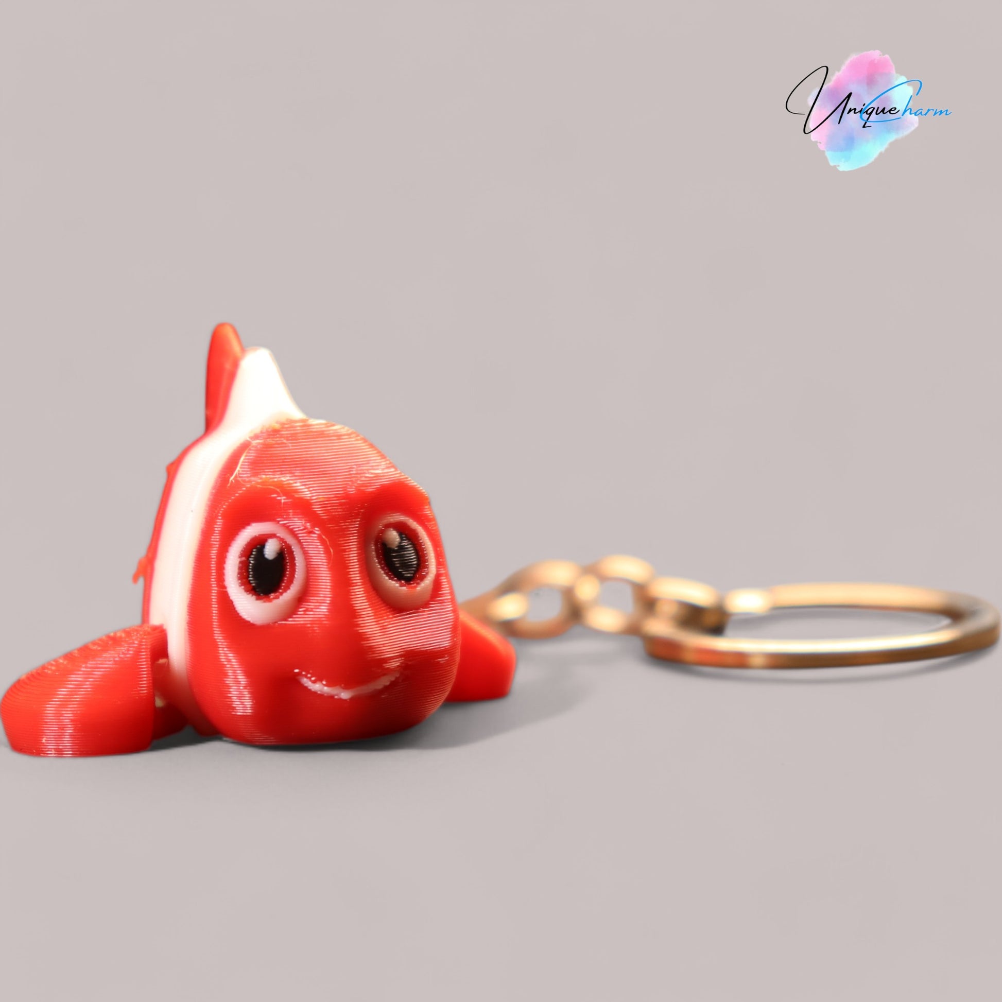 3D printed articulated clown fish toy in vibrant two-tone colors, featuring a cute face and flexible, lifelike movement, perfect as a keychain or playful ocean-themed gift.