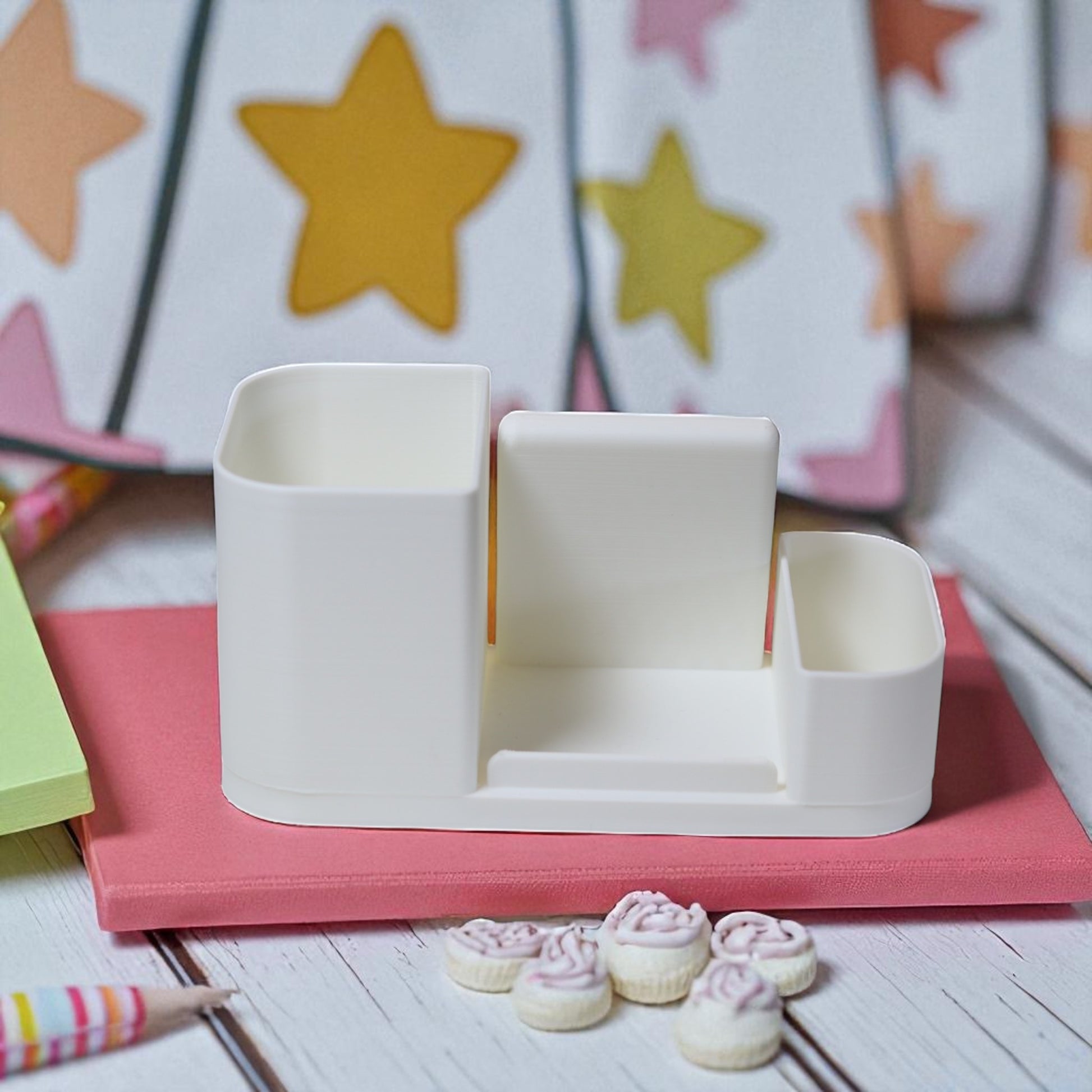 Kids desk organiser with phone stand, pencil/brush holder and sticky-note slot, 20×11×10 cm—white.Front view: organiser holding markers, smartphone in stand, and 3×3 sticky notes—back-to-school desk tidy.