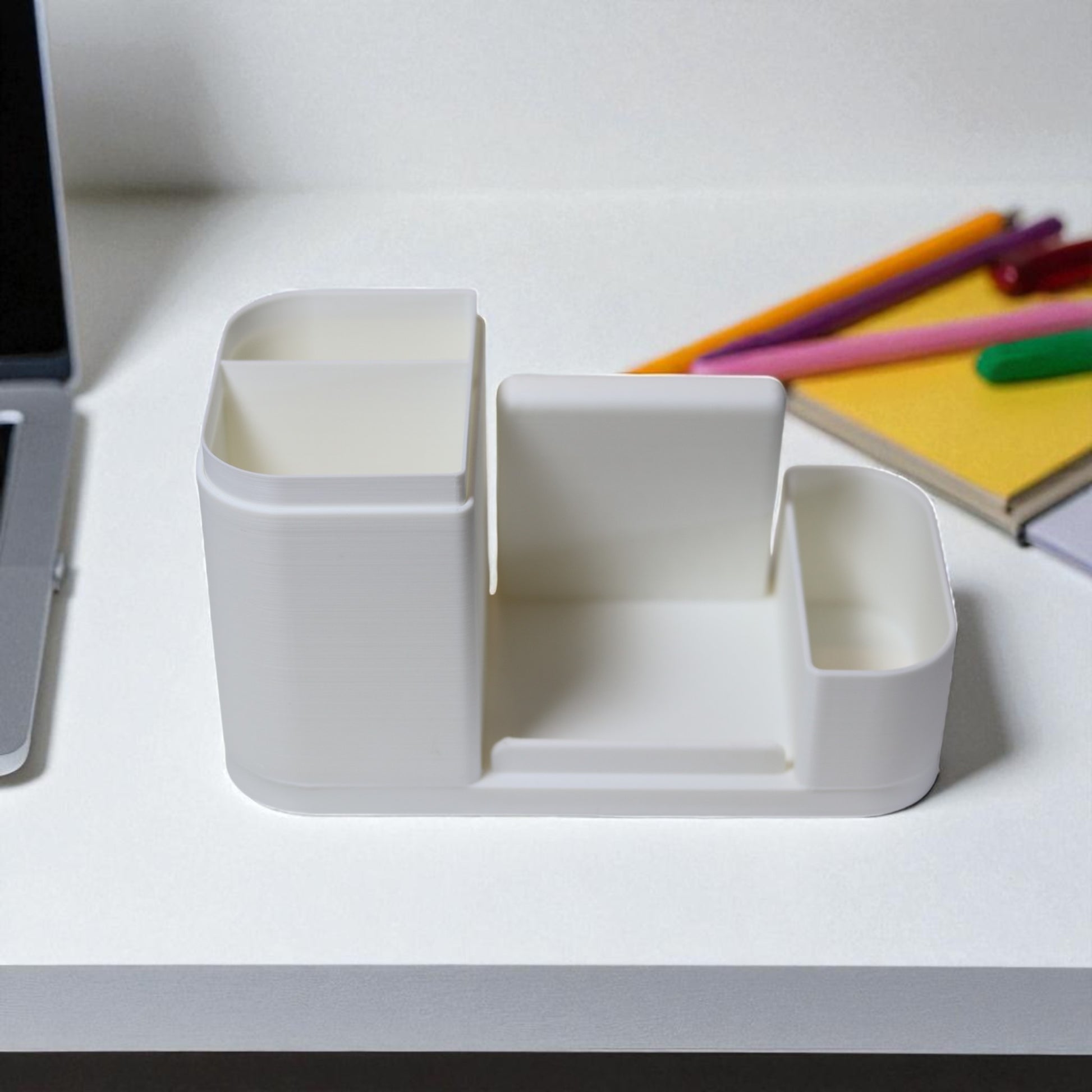 Kids desk organiser with phone stand, pencil/brush holder and sticky-note slot, 20×11×10 cm—white.Front view: organiser holding markers, smartphone in stand, and 3×3 sticky notes—back-to-school desk tidy.