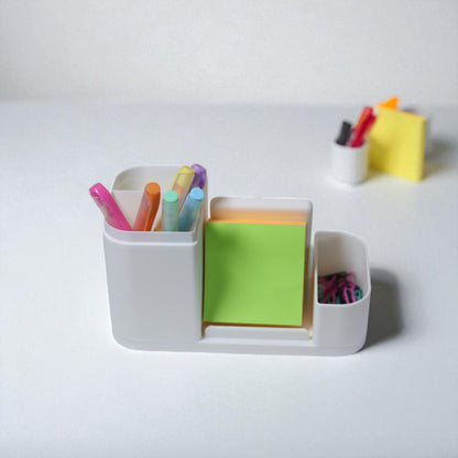 Kids desk organiser with phone stand, pencil/brush holder and sticky-note slot, 20×11×10 cm—white.Front view: organiser holding markers, smartphone in stand, and 3×3 sticky notes—back-to-school desk tidy.