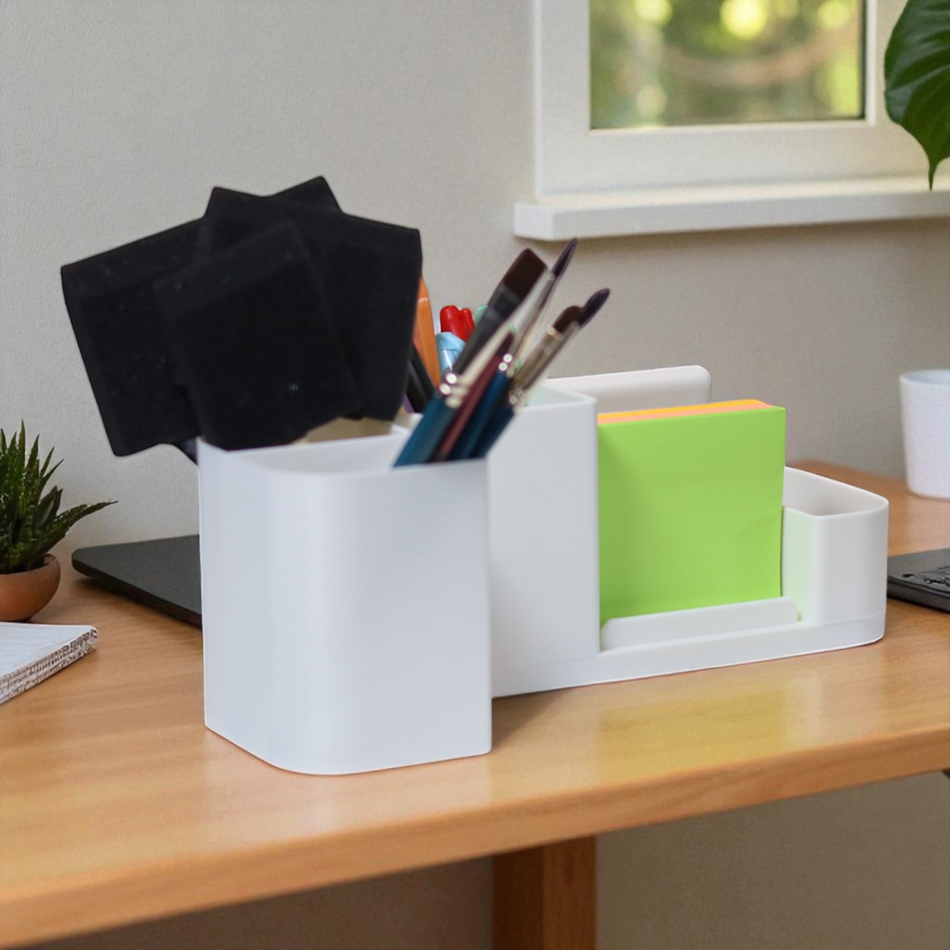 Kids desk organiser with phone stand, pencil/brush holder and sticky-note slot, 20×11×10 cm—white.Front view: organiser holding markers, smartphone in stand, and 3×3 sticky notes—back-to-school desk tidy.