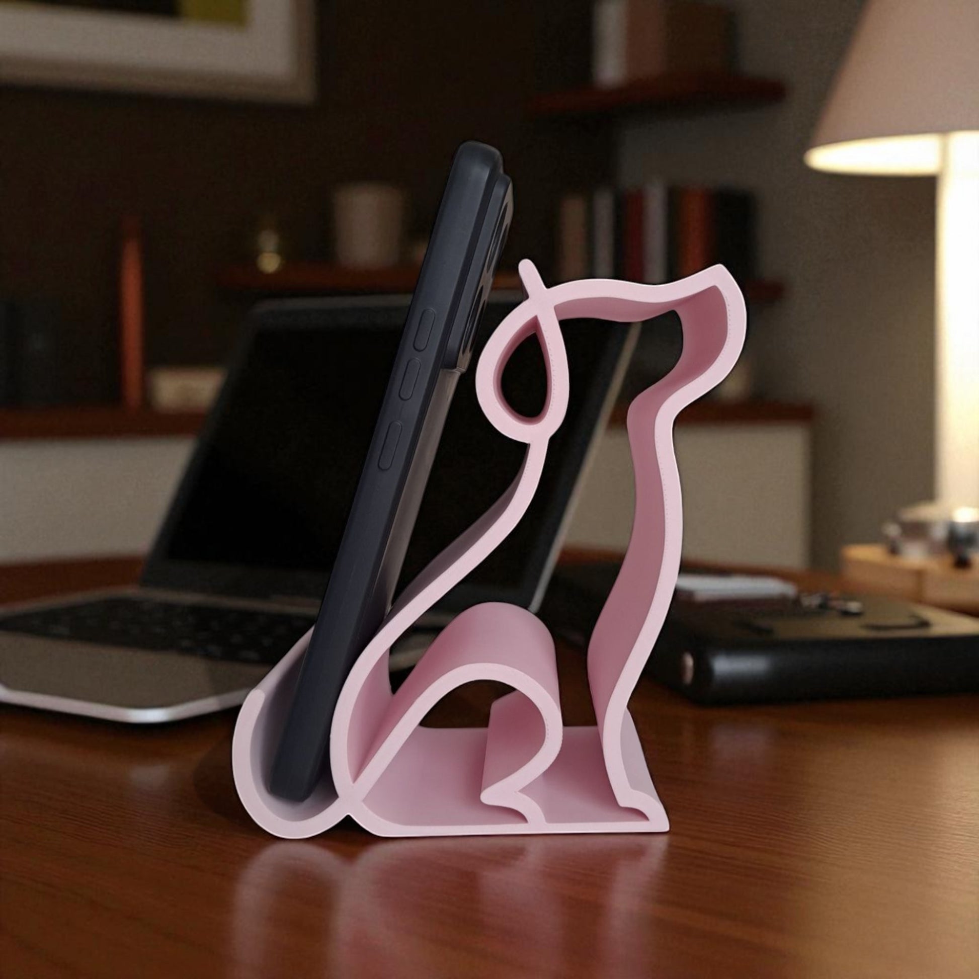3D printed pink dog-shaped phone holder for desk, used to support a smartphone, tablet, or Kindle, ideal for pet lovers and home office decor