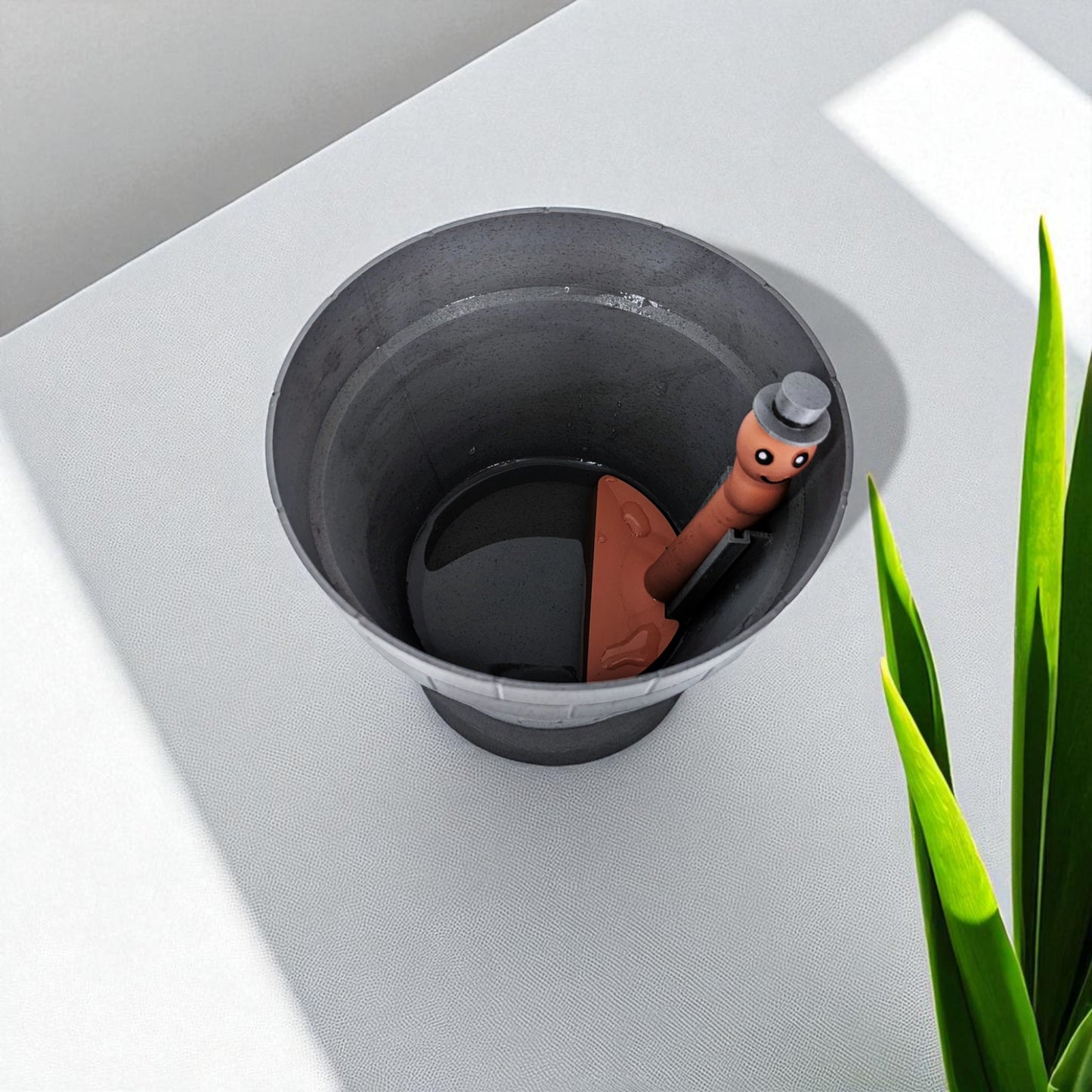 a clever and charming worm rise planter featuring a worm-shaped water indicator that rises to signal when the plant has enough water. perfect for plant lovers who value functionality and fun design