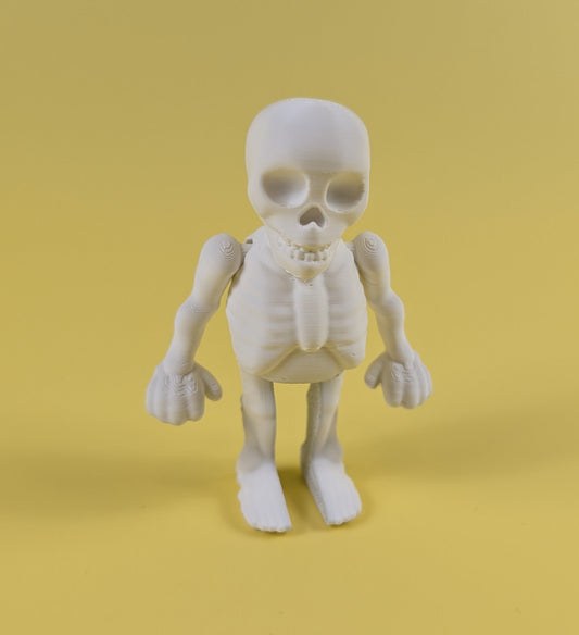 White 3D-printed skeleton figurine raising both arms on a yellow background; spooky-cute desk buddy with lightly poseable joints.