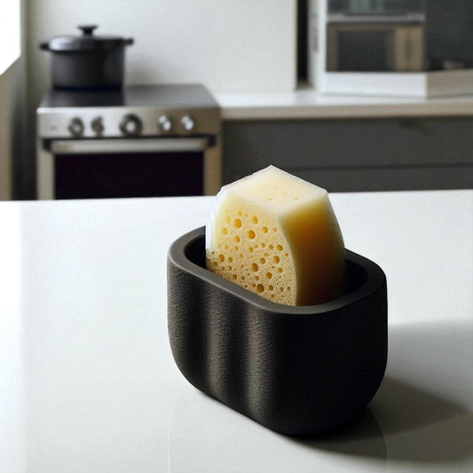 Black sponge holder with a yellow sponge on a kitchen counter