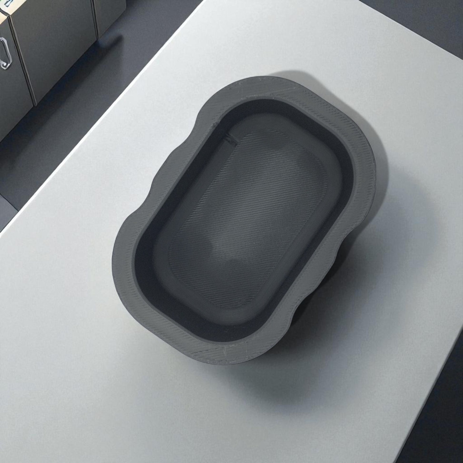 Black sponge holder with a yellow sponge on a kitchen counter