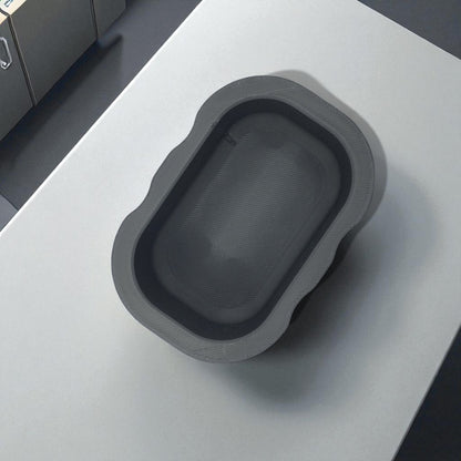 Black sponge holder with a yellow sponge on a kitchen counter