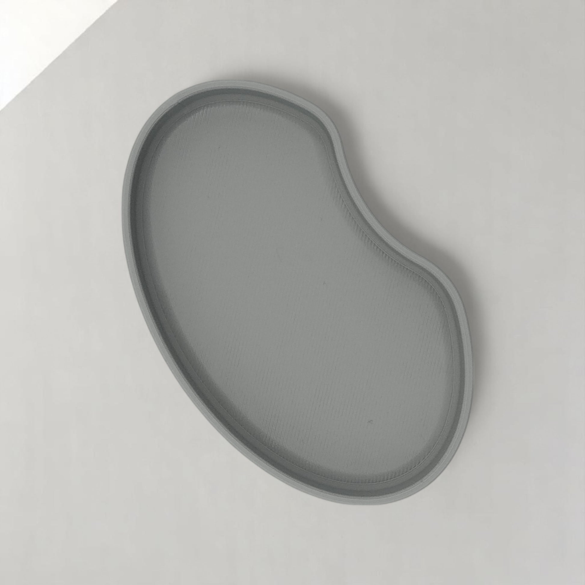 Set of two bean shaped desk organizers in different sizes for tidy and stylish storage.