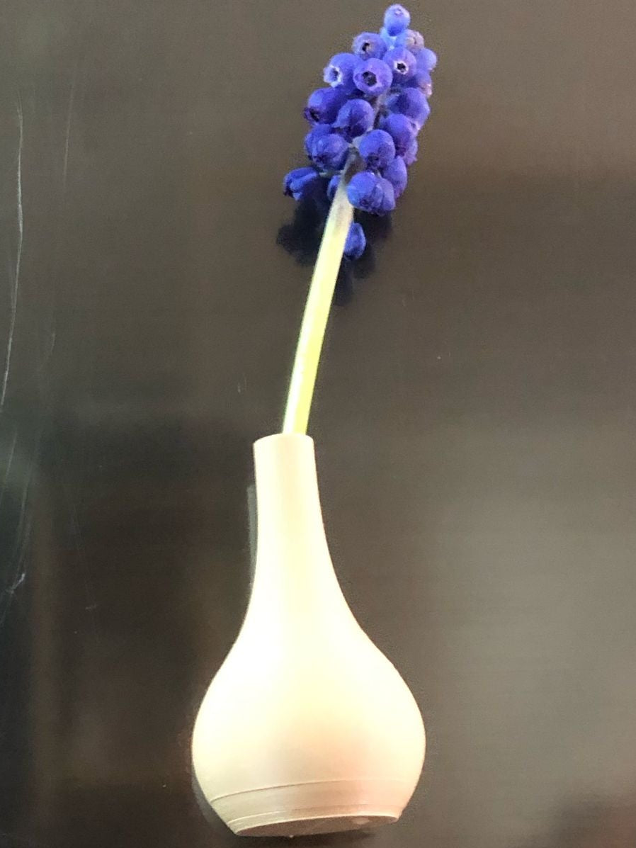 Set of 5 small magnetic mini vases in random earthy brown tones, 3D printed with a modern design, displayed on a fridge holding tiny flowers.

