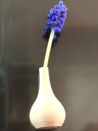 Set of 5 small magnetic mini vases in random earthy brown tones, 3D printed with a modern design, displayed on a fridge holding tiny flowers.

