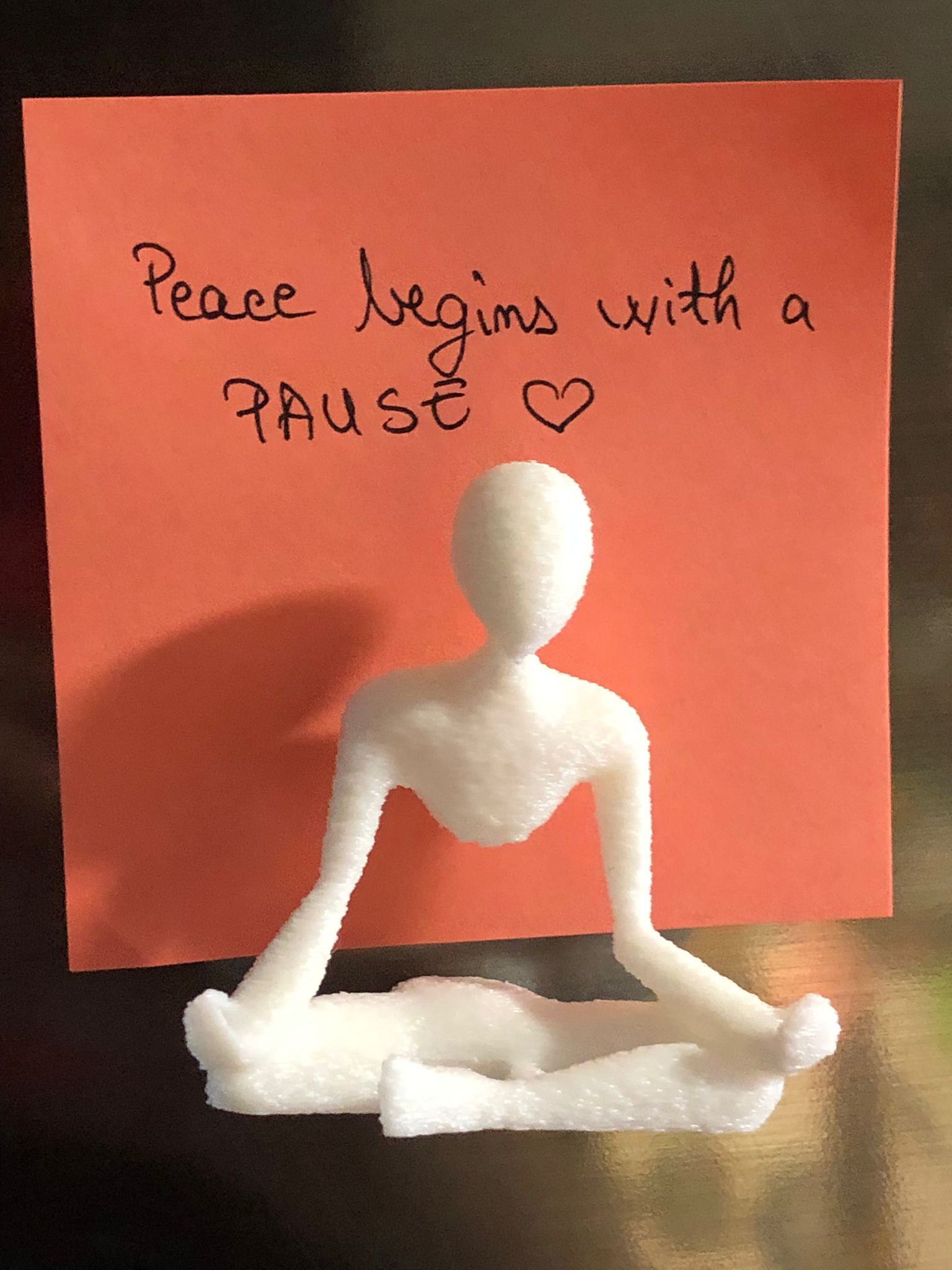 Set of two white 3D printed fridge magnets shaped like minimalist faceless human figures in yoga and meditation poses, displayed on a metallic surface.